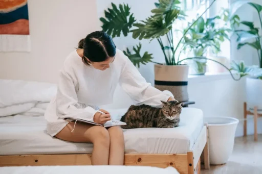 mujer consintiendo a su gato en el sofá